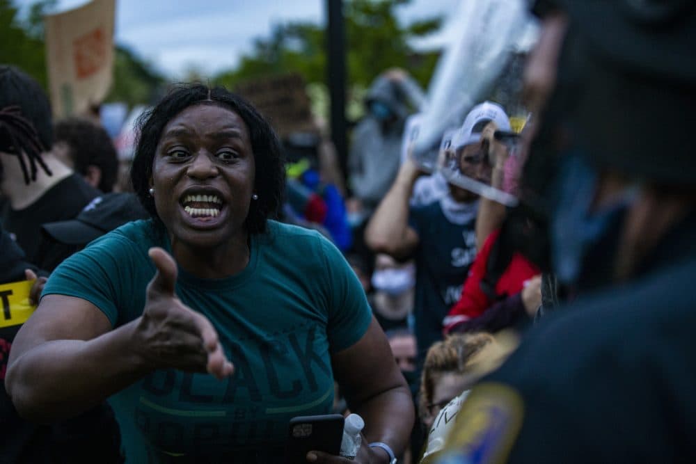 A protester pleads with Boston Police to join their cause in front of Forest Hills Station in Jamaica Plain. (Jesse Costa/WBUR)