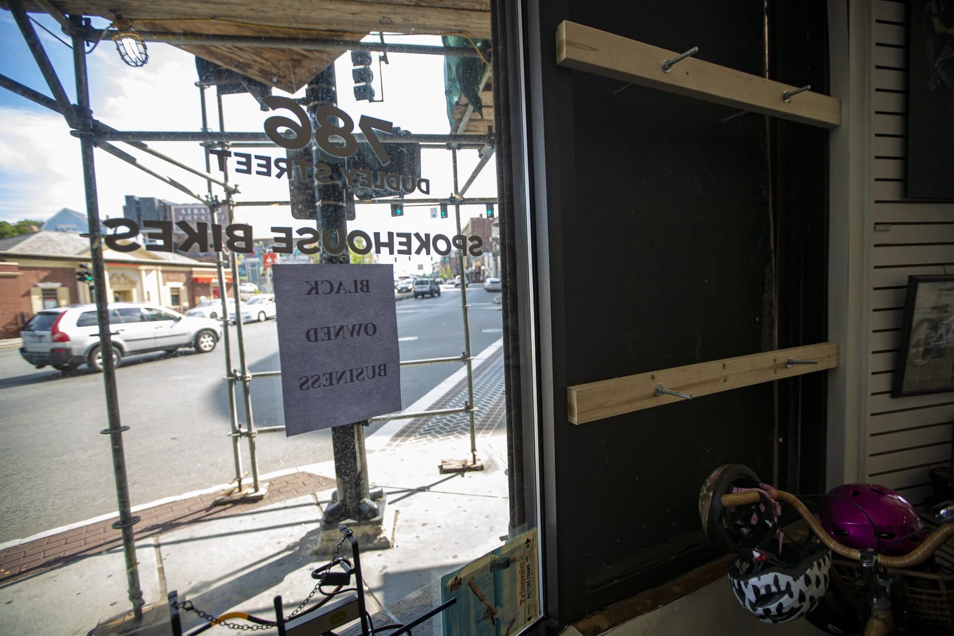 The window of Spokehouse that was damaged during the looting after the protest on May 31. A sign reads "Black Owned Business." (Jesse Costa/WBUR)