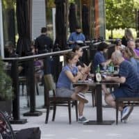Guests eating outside at Lola 42, with a view of the harbor. (Robin Lubbock/WBUR)