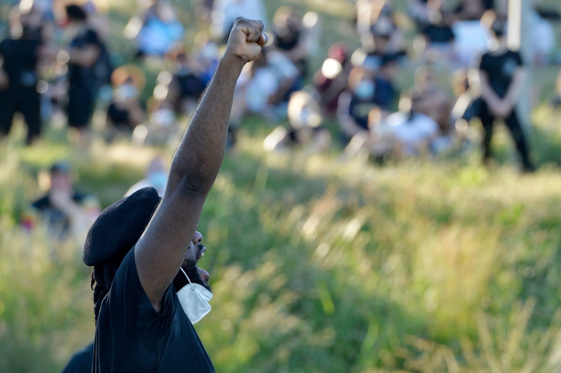 A man raises his fist during a Juneteenth "Funk the Police" musical rally and protest against police brutality at Ronan Park in Boston. (Joseph Prezioso/AFP via Getty Images)