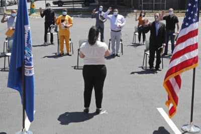 New citizens are sworn in while observing social distancing, outside the U.S. Citizenship and Immigration Services building, Thursday, June 4, 2020, in Lawrence, Mass. (Elise Amendola/AP)