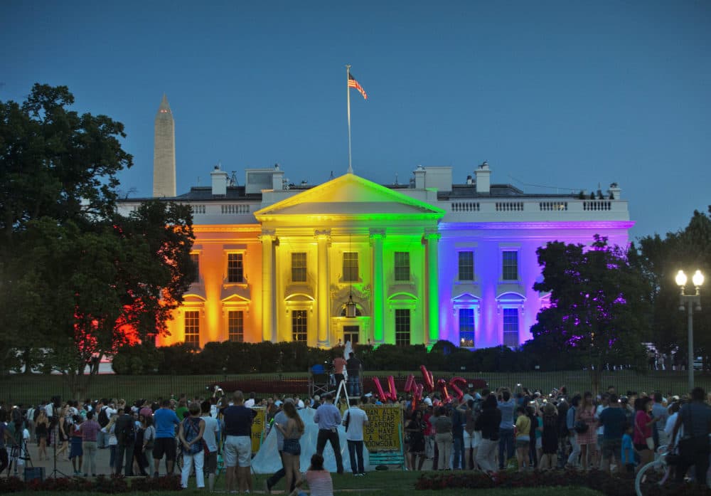 In this Friday, June 26, 2015 file photo, people gather in Lafayette Park to see the White House illuminated with rainbow colors in commemoration of the Supreme Court's ruling to legalize same-sex marriage in Washington. (Pablo Martinez Monsivais/AP)