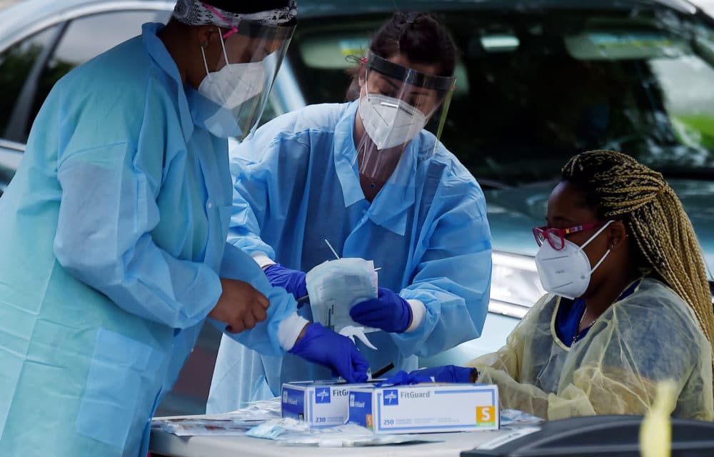 Health workers prepare to give people free COVID-19 tests. (OLIVIER DOULIERY/AFP via Getty Images)