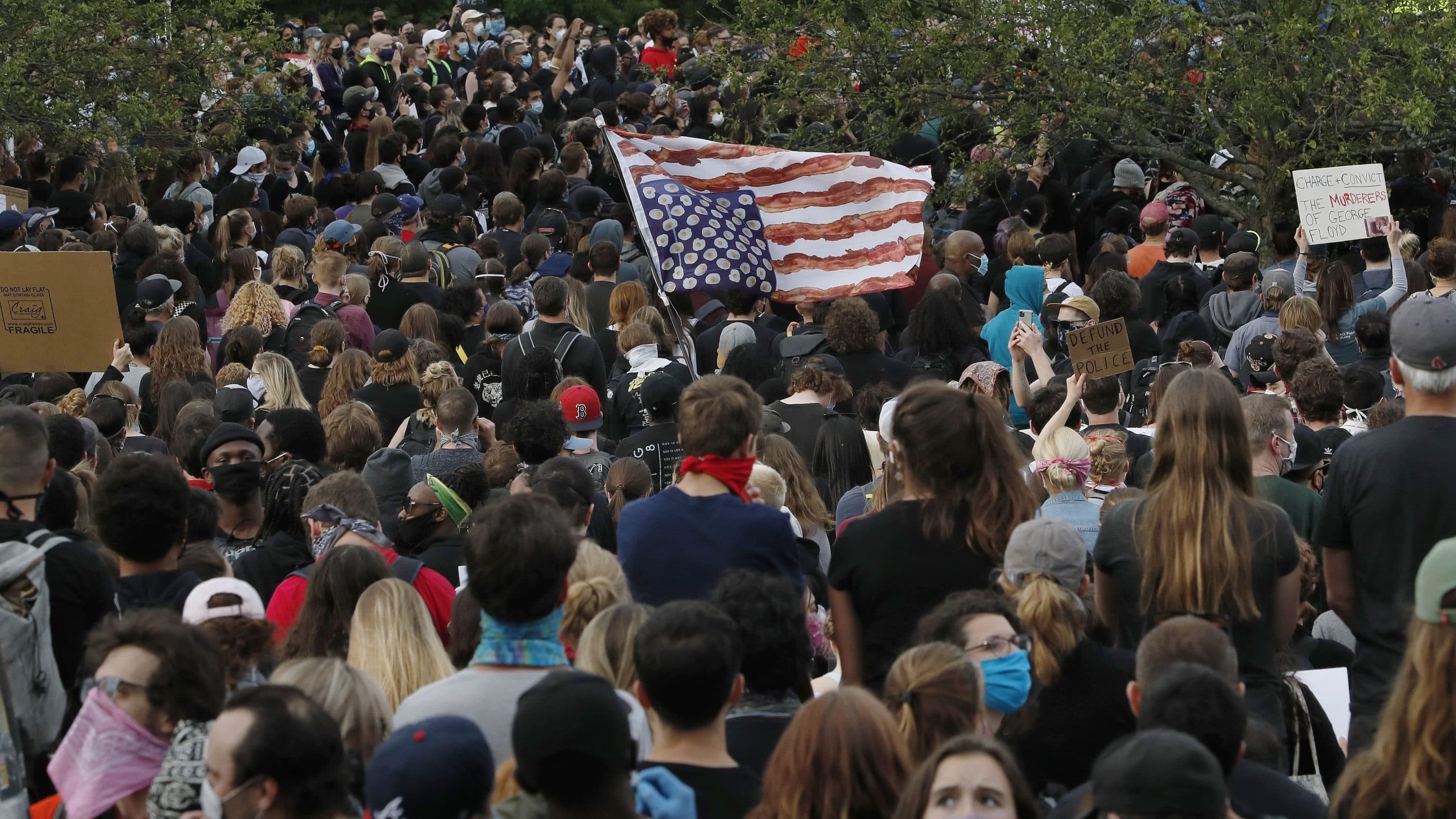 A stylized American flag is held upside down among hundreds gathered in Boston on Tuesday to protest against police brutality following the death of George Floyd. (Charles Krupa/AP)