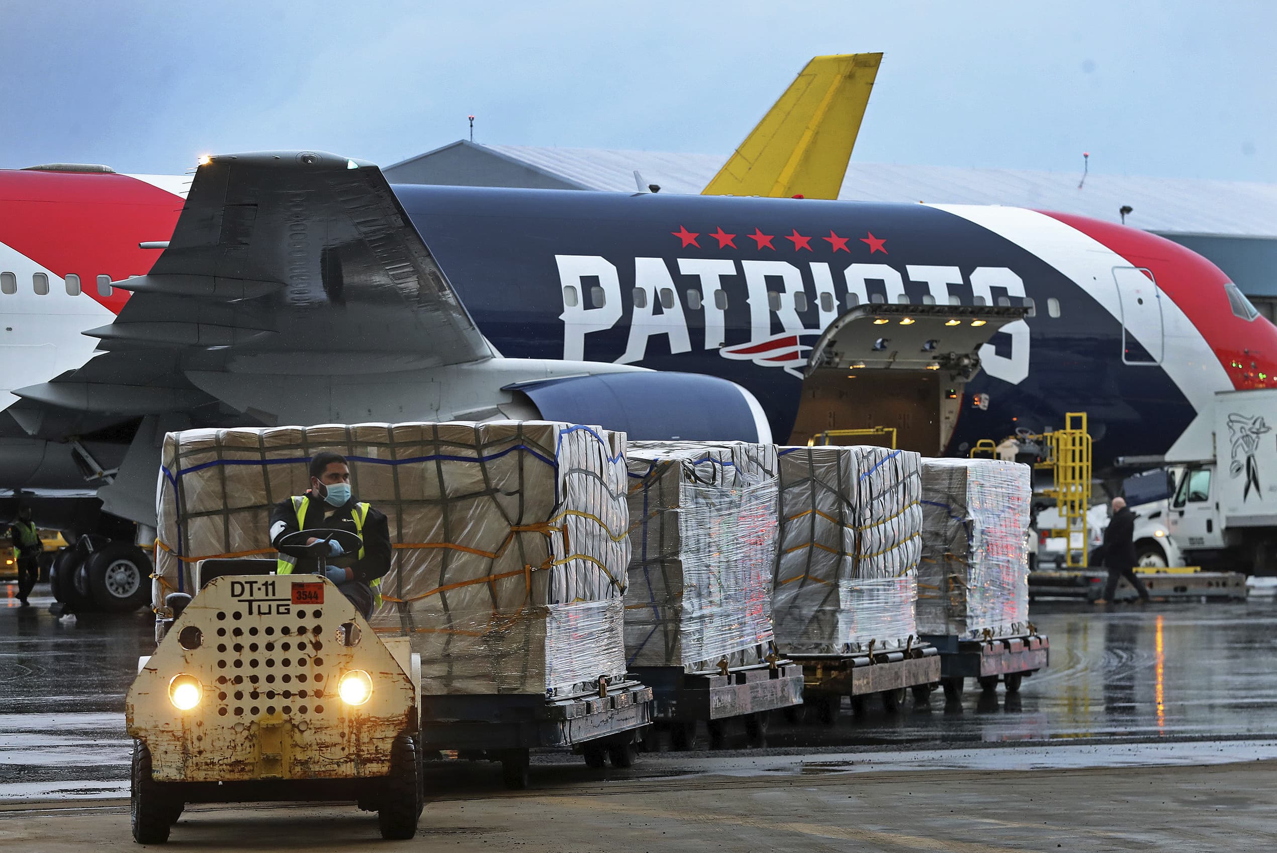 Palettes of N95 respirator masks are off-loaded from the New England Patriots football team's customized Boeing 767 jet on the tarmac on April 2, 2020, at Boston Logan International Airport in Boston, after returning from China. (Jim Davis/The Boston Globe via AP, pool)