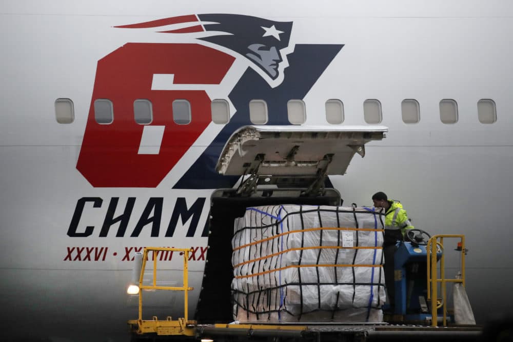 Palettes of masks are off-loaded from the New England Patriots football team's customized Boeing 767 jet on the tarmac on April 2 at Logan Airport in Boston, after returning from China. (Elise Amendola/AP)