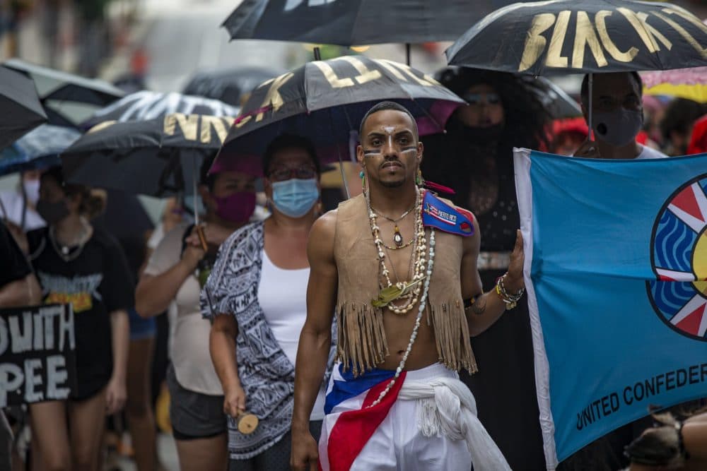 Protesters march down Congress Street with umbrellas toward City Hall Plaza during the Dismantle Now! BIPOC Solidarity Against White Supremacy demonstration. (Jesse Costa/WBUR)