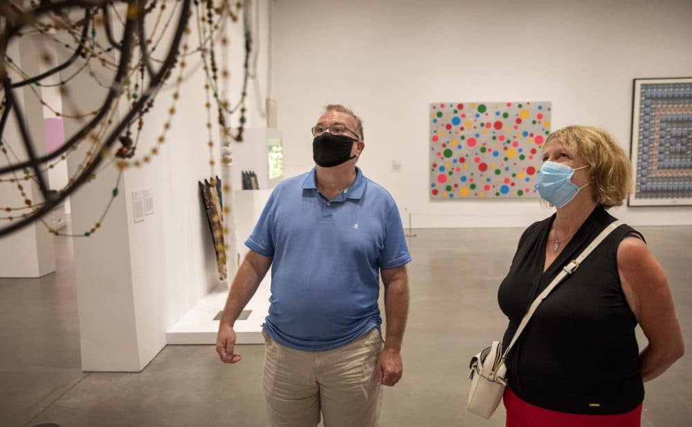 Patrick McAvoy and Theresa Bergstrom, of Boston, look at artist Nick Cave's "Soundsuit" at the ICA. (Robin Lubbock/WBUR)