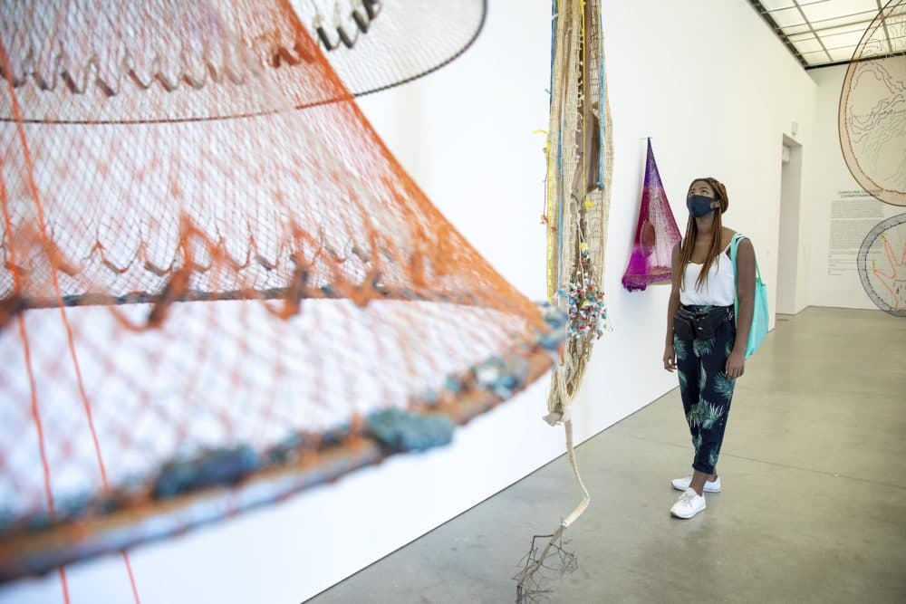 Jacarrea Garraway looks up at an installation in Carolina Caycedo's Cosmotarrayas exhibit at the ICA. (Robin Lubbock/WBUR)