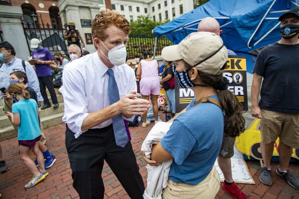 U.S. Rep. Joe Kennedy III speaks to a rally participant before the Strike for Black Lives. (Jesse Costa/WBUR)