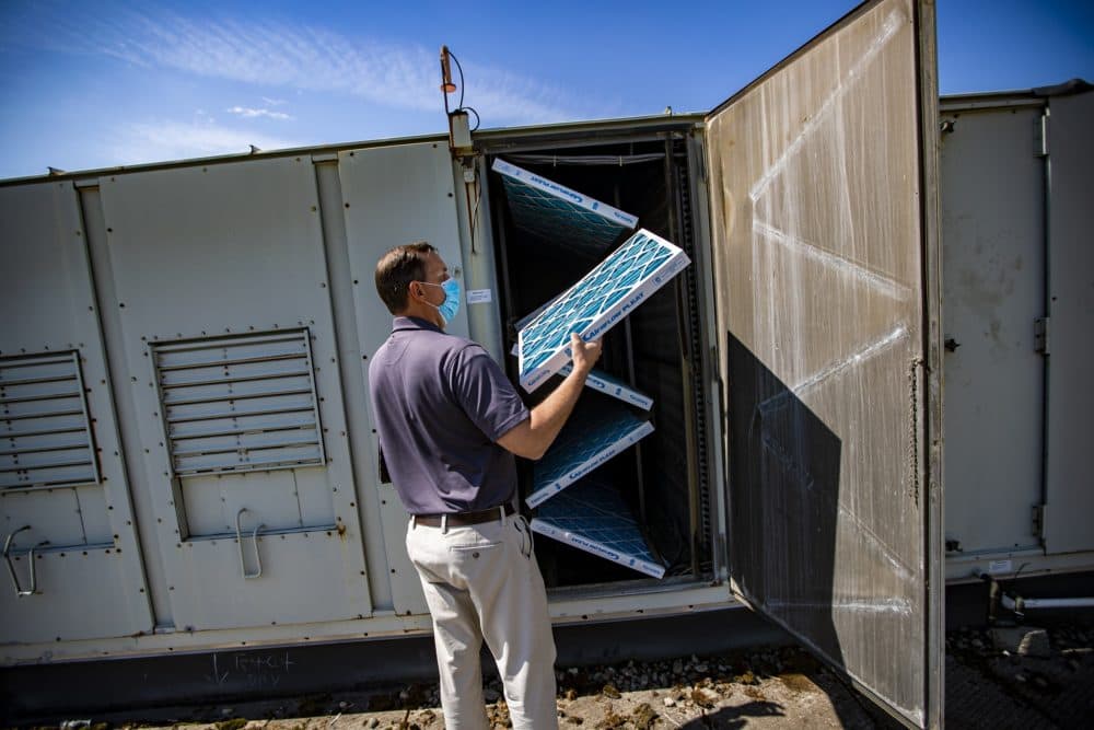During an inspection at West Somerville Neighborhood School, engineer Scott LeClair pulls out an air filter from an central air conditioning unit that he finds are only 30 percent efficient. They will be upgraded with filters that closer to 95 percent efficient. (Jesse Costa/WBUR)