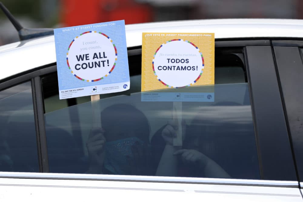 In this June 25, 2020, file photo, two young children hold signs through the car window that make reference to the 2020 U.S. Census as they wait in the car with their family at an outreach event in Dallas. (Tony Gutierrez/AP Photo)
