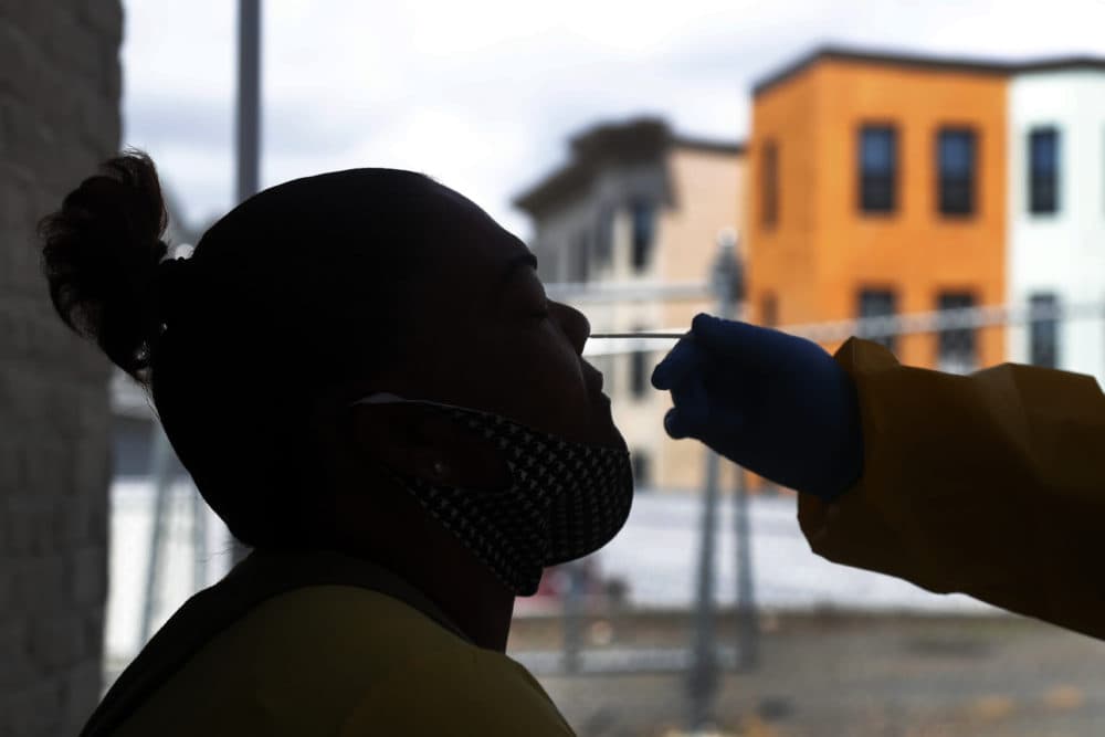 A woman receives a COVID-19 test at the Whittier Street Health Center's mobile test site, July 15, 2020, in Dorchester. (Elise Amendola/AP)