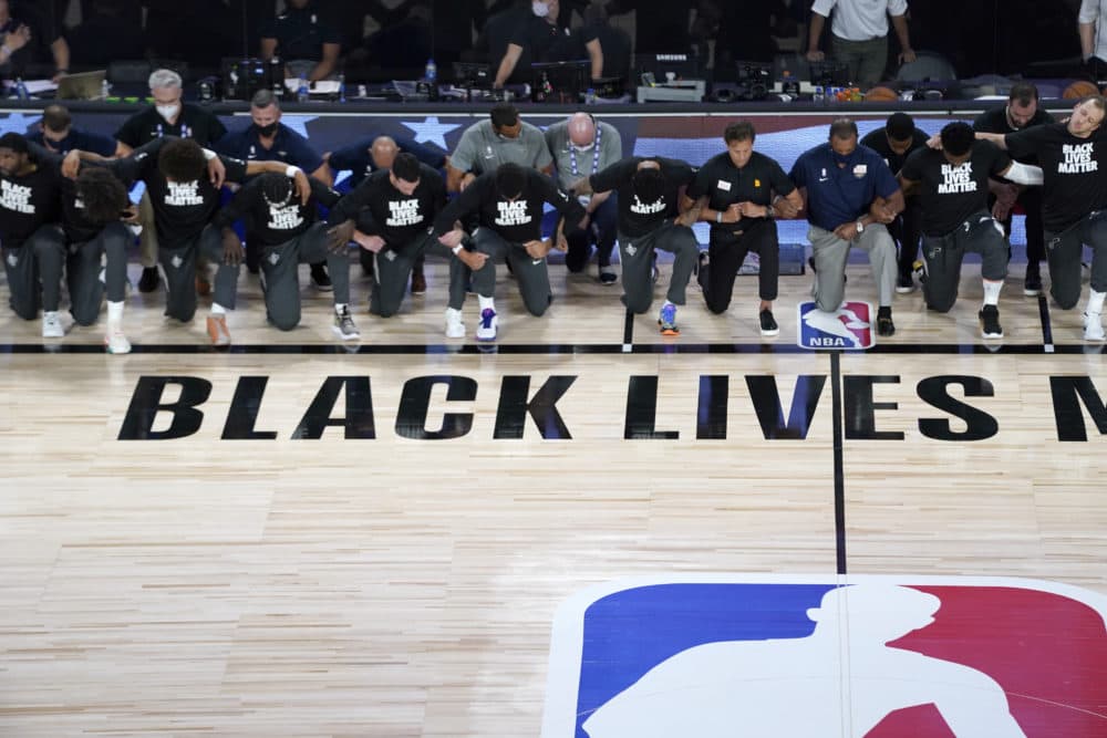 Members of the Pelicans and Jazz kneel together during the national anthem before their game on Thursday. (Ashley Landis/AP)