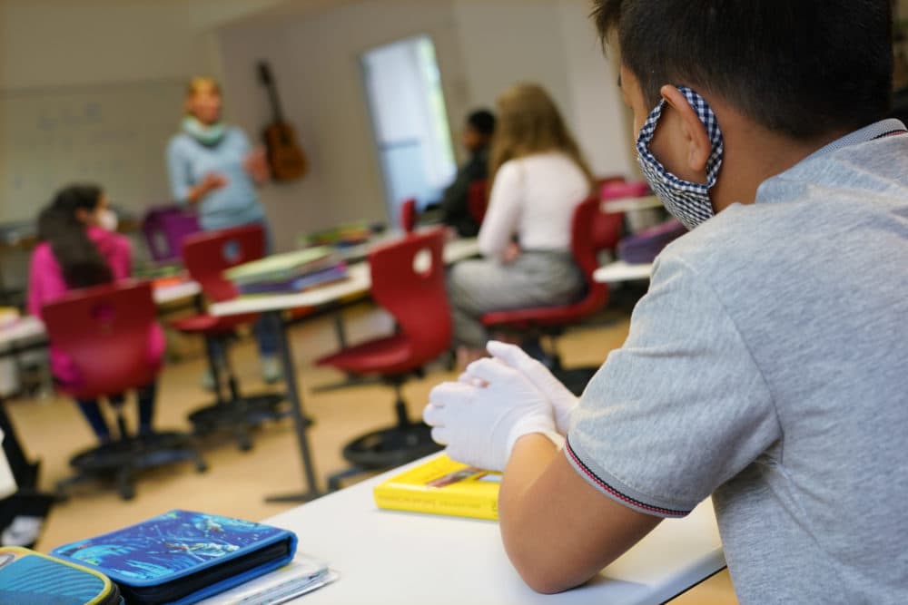 A sixth grader wears a protective face mask and gloves as he attends class for the first time since March at the GutsMuths Grundschule elementary school during the novel coronavirus crisis on May 4, 2020 in Berlin, Germany. (Sean Gallup/Getty Images)