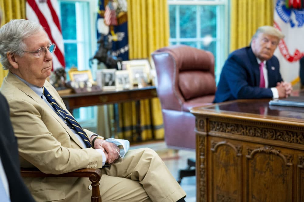 Senator Mitch McConnell in the Oval Office with President Trump in the background at the desk