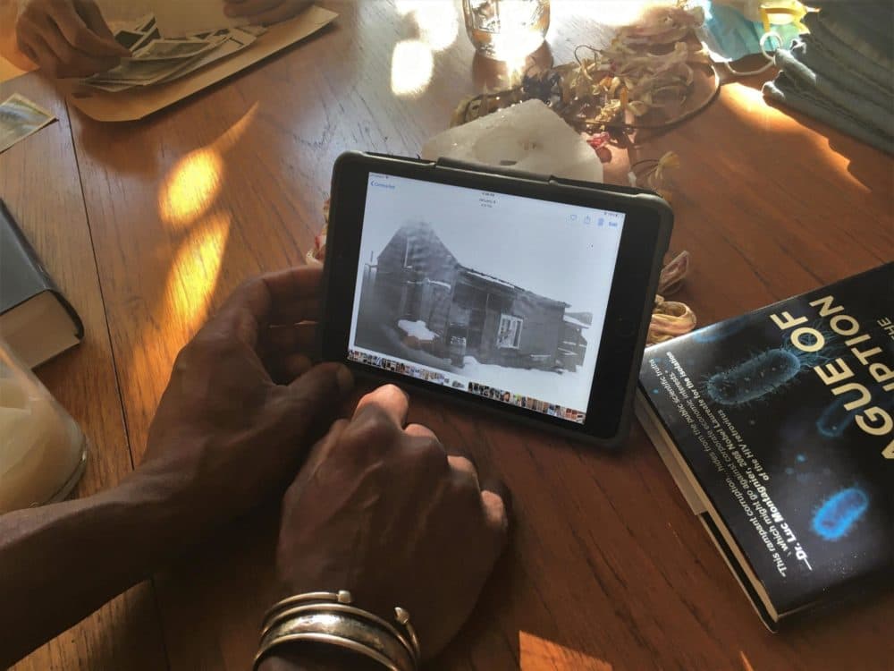 Gamal Buhaina holds an image of the original farmhouse belonging to his grandparents, John and Amelie Bates. (Anna Van Dine/VPR)