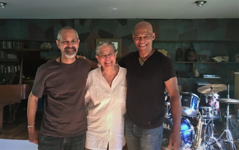 Grace Bates, center, her son Yawu Miller, left, and Gamal Buhaina, right, standing in Buhaina's home in Fayston. (Anna Van Dine/VPR)