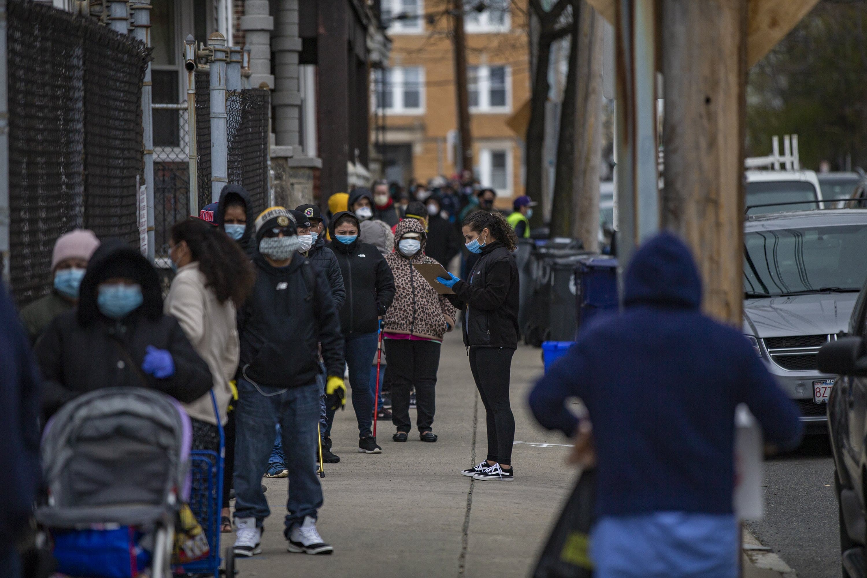 A line extends down Chestnut Street for food distribution being done by the Salvation Army in Chelsea in April. (Jesse Costa/WBUR)