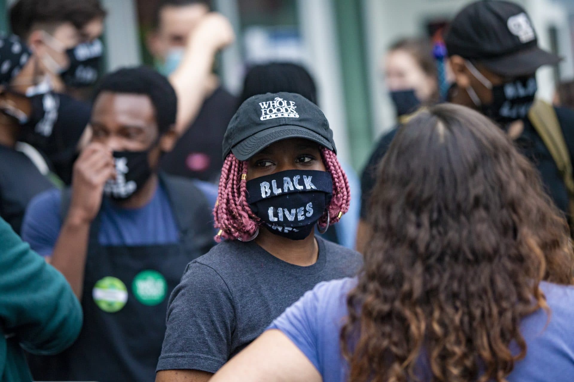 A group of Whole Foods employees dismissed by managers for wearing Black Lives Matter masks during their shifts gather outside of the Whole Foods on River Street in Cambridge in July 2020. (Jesse Costa/WBUR)