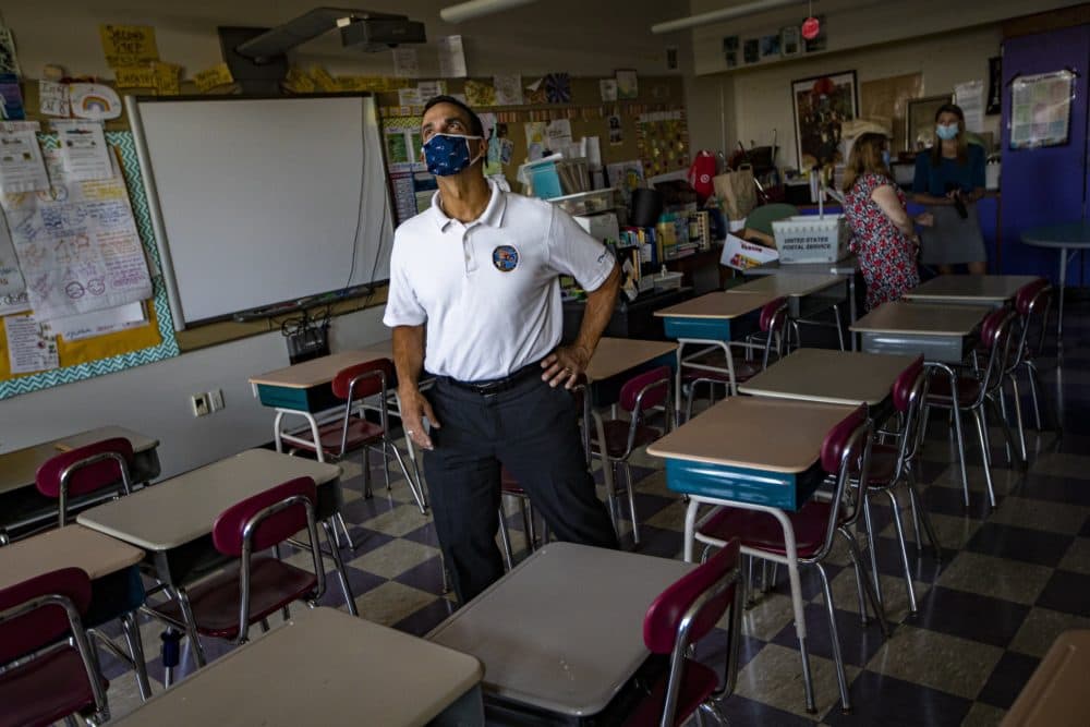 Somerville Mayor Joseph Curtatone examines the ceiling for ventilation duct during a visit to assess the ventilation at West Somerville Community School. (Jesse Costa/WBUR)