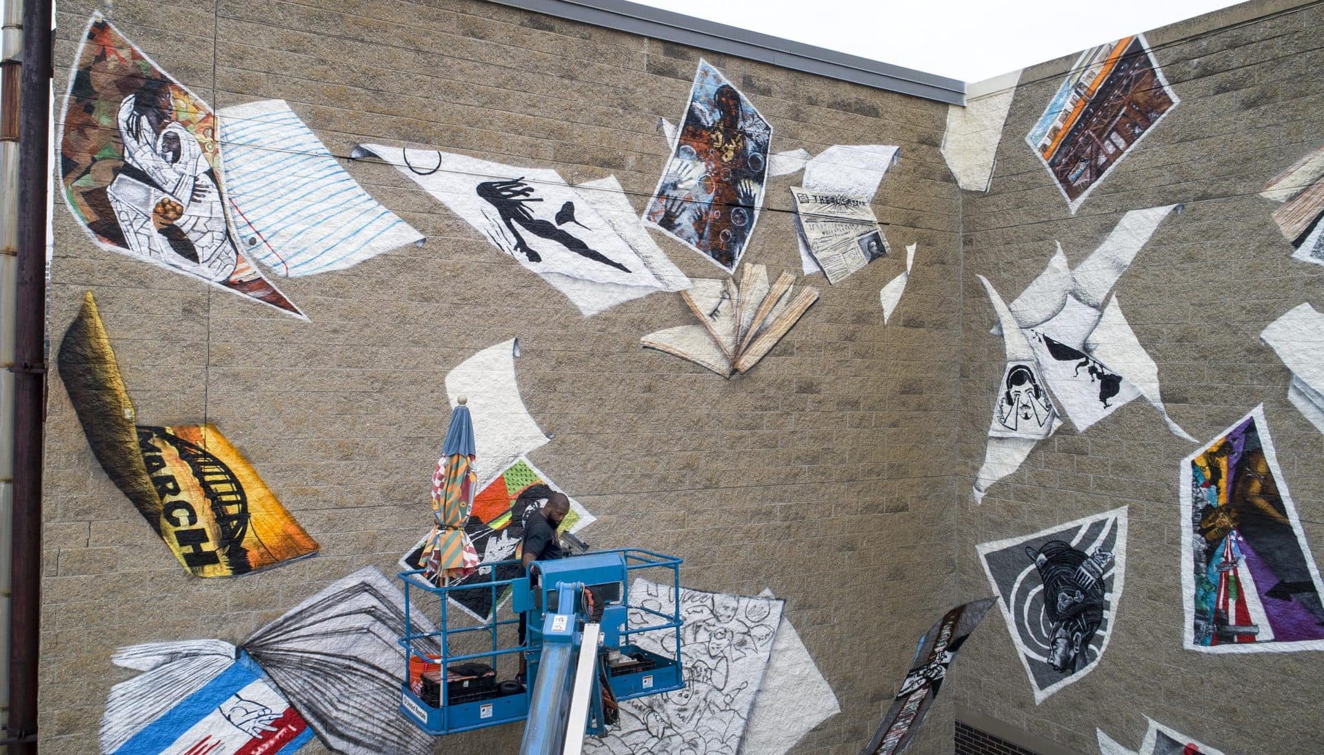 Gibbs references various artists' work bursting out of the basketball player's backpack in the "Breathe Life" mural at Madison Park Technical Vocational High School. (Robin Lubbock/WBUR)