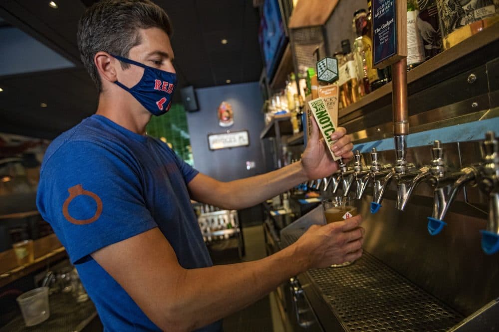 Billy Moran pours a beer at Cornwall’s in Kenmore Square. (Jesse Costa/WBUR)