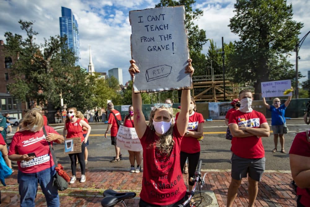Arlington schoolteacher Tania Phillips holds a sign that reads “I can’t teach from the grave.” Hundreds of members of the Massachusetts Teachers Union attended a rally at the State House demanding Governor Charlie Baker to safely reopen schools, Aug. 19, 2020. (Jesse Costa/WBUR)