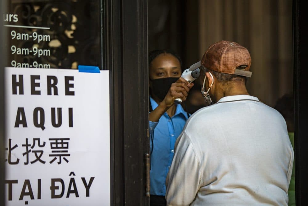 Voters received temperature checks before entering the Boston Public Library to vote. (Jesse Costa/WBUR)