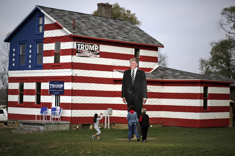 A young visitor takes a photo of a giant photo of Republican candidate for president Donald Trump in front of the Trump House owned by Leslie Rossi in Youngstown, Pa, Tuesday, Nov. 8, 2016. (Gene J. Puskar/AP Photo)