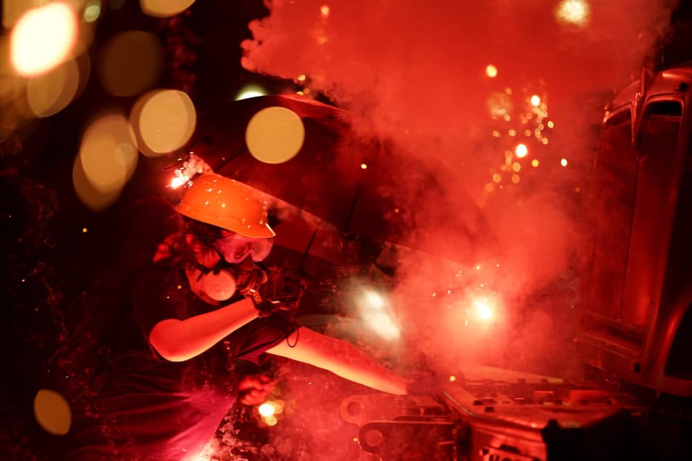 An explosive device detonates as a protester pushes back on an armored vehicle clearing the park of demonstrators during clashes outside the Kenosha County Courthouse, late Tuesday. (David Goldman/AP)
