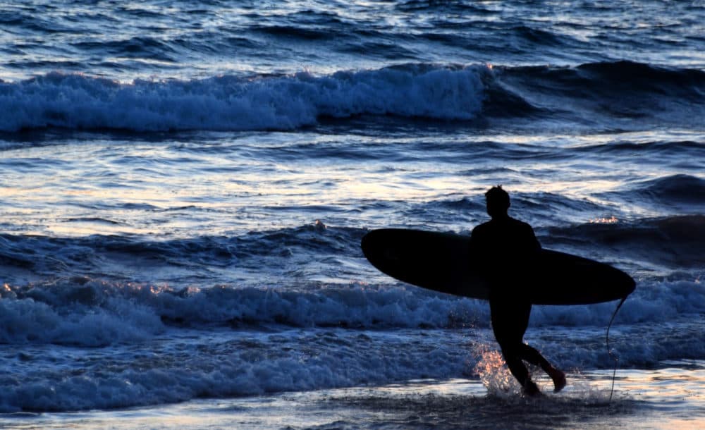 A surfer heads for a wave at sunset at San Clemente State Beach in San Clemente on Friday, August 7, 2020. (Keith Birmingham/Getty Images)