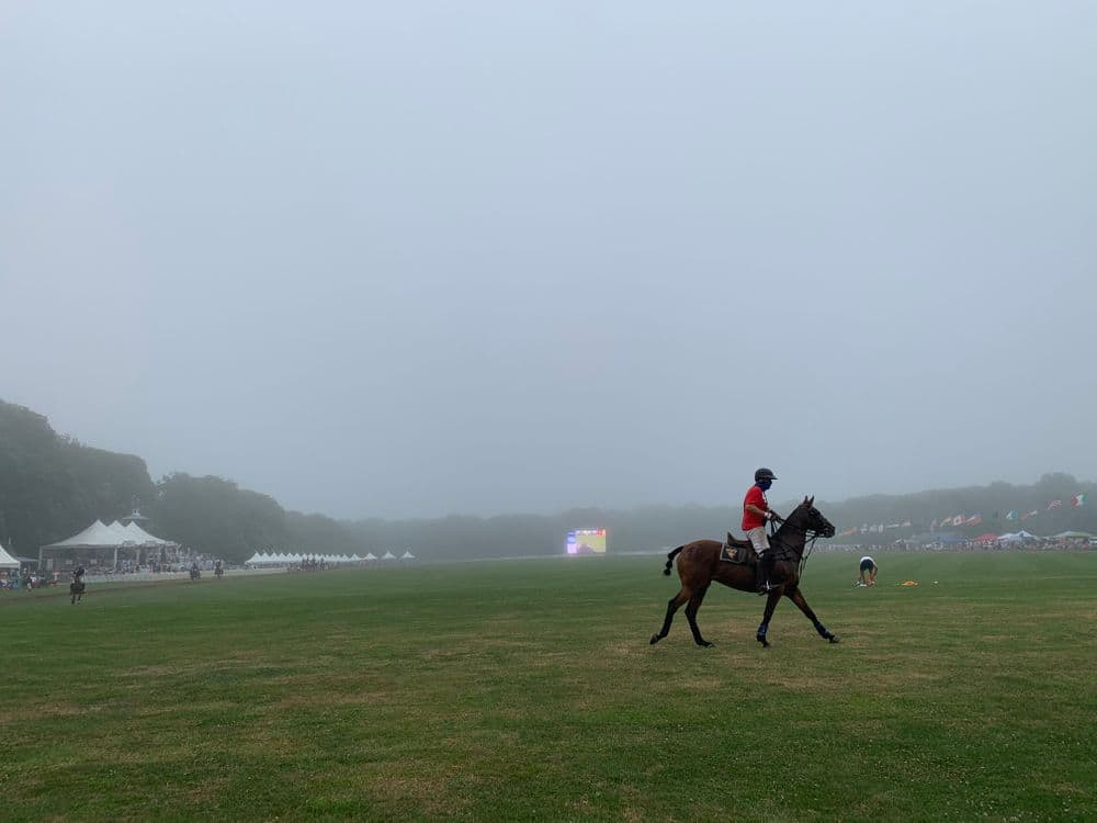 A player takes a final lap as fog covers the polo field at Glen Farm. (Antonia Ayres-Brown/The Public's Radio)