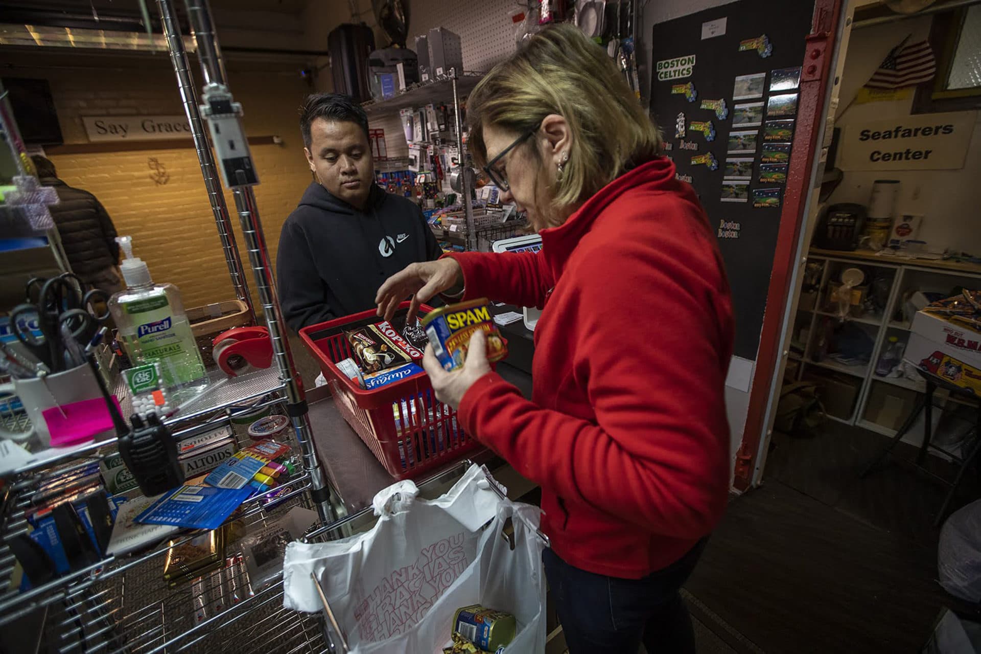 Sharon Cushing, who runs the mission with her husband, the chaplain, rings a cruise ship worker out inside the tiny convenience store. (Jesse Costa/WBUR)