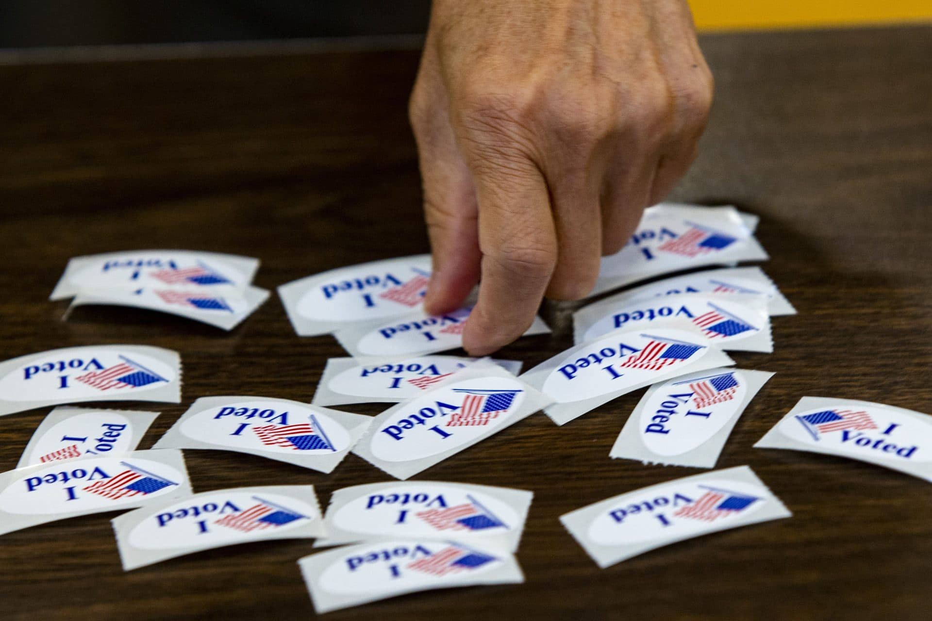 A voter picks up an “I Voted” sticker at Ward 1 in East Boston High School on election day. (Jesse Costa/WBUR)
