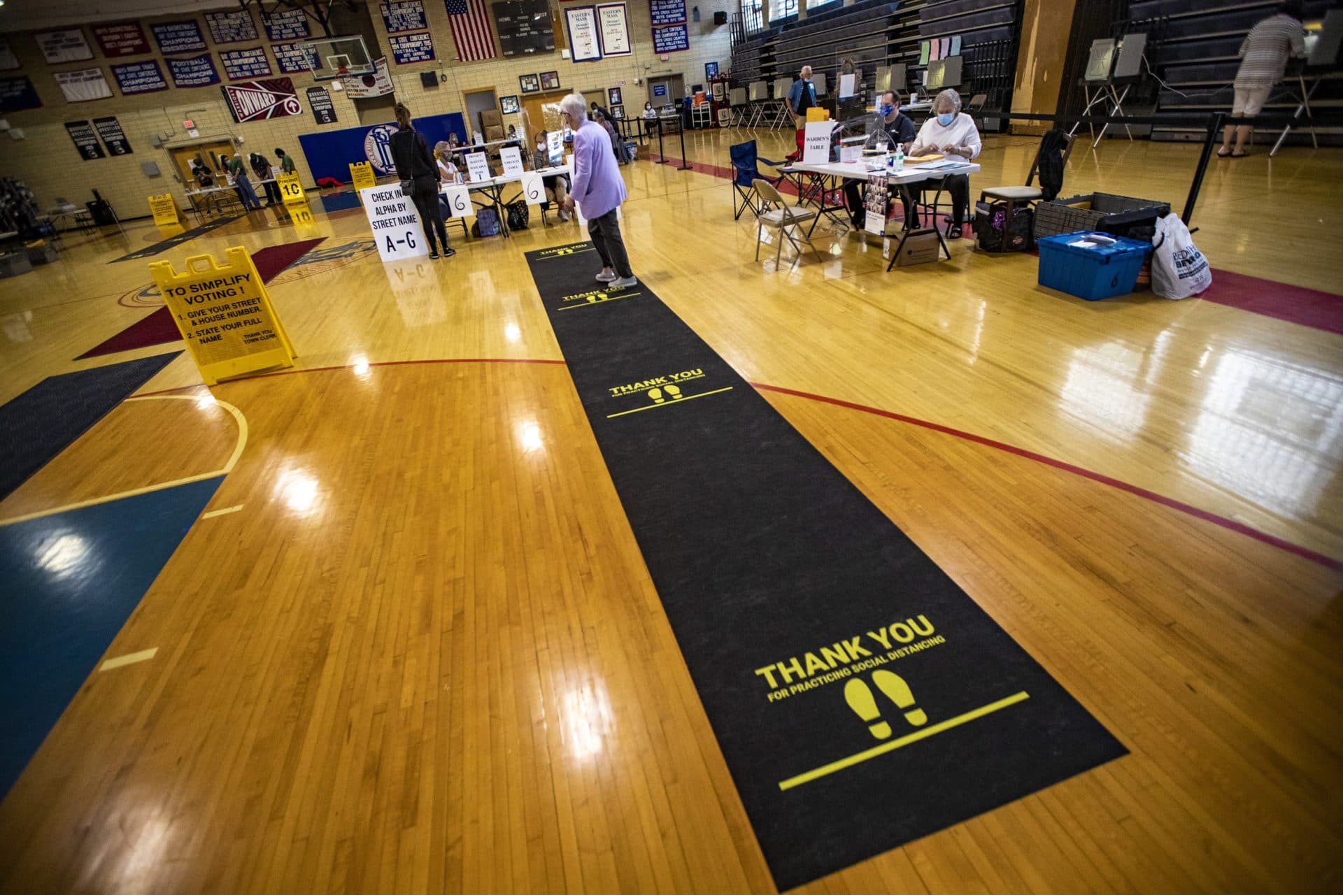 Voters check in to receive their ballots at Brookline High School on election day. (Jesse Costa/WBUR)