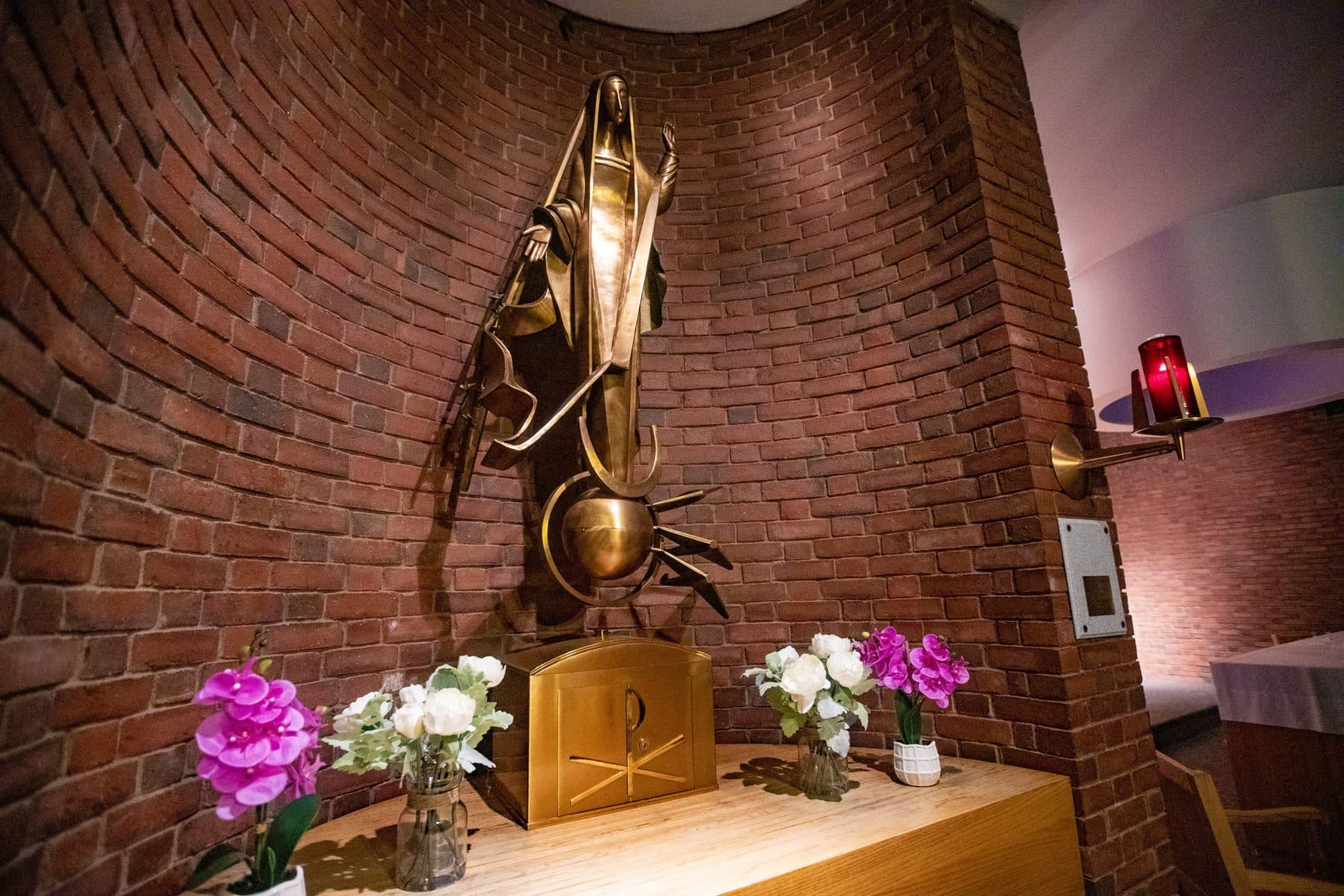 A statue of the Virgin Mary standing atop a globe with planes flying around it at the Our Lady of the Airways chapel at Logan Airport. (Jesse Costa/WBUR)
