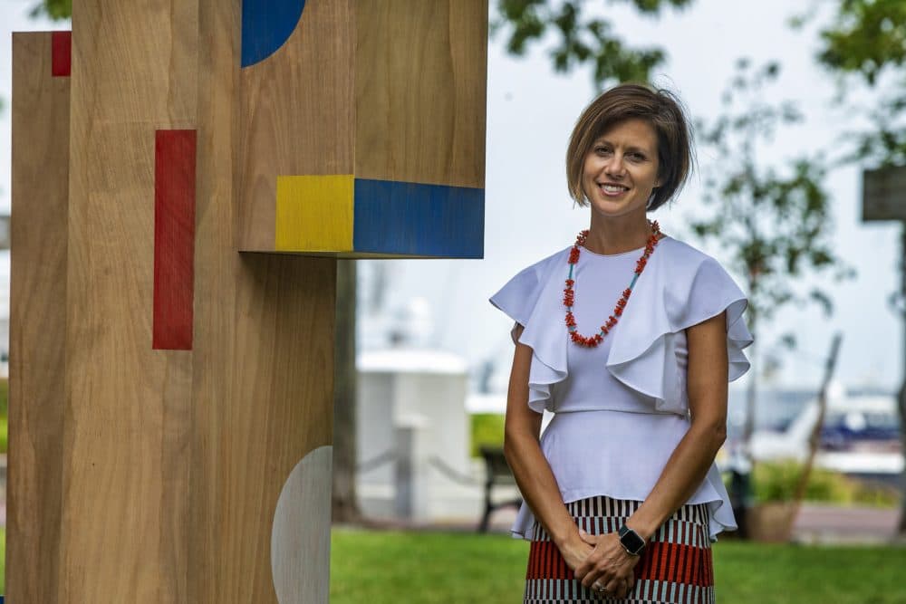 Kate Gilbert, executive director of Now + There, stands next to one of the structures in "The Shape of Play" art installation. (Jesse Costa/WBUR)
