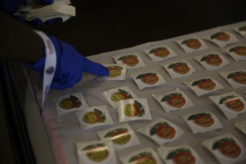 A polling place attendant puts out "I'm a Georgia Voter" stickers on a table at Park Tavern for the Georgia's primary election on Tuesday, June 9, 2020, in Atlanta. (Brynn Anderson/AP Photo)