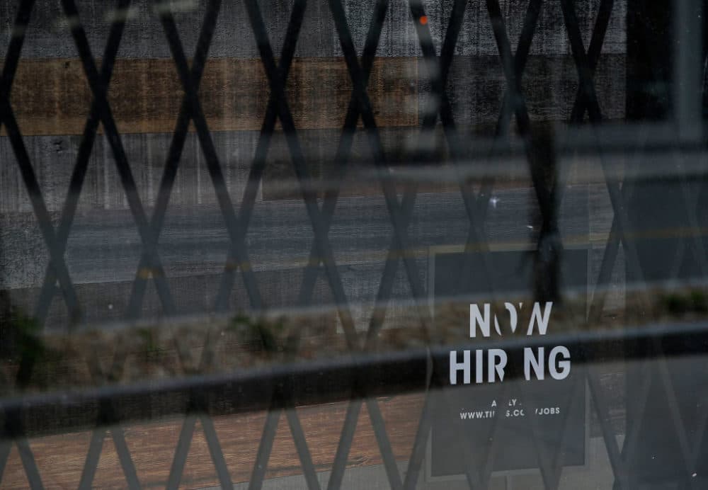 A Now Hiring sign is seen behind bars at Tillys in Assembly Square in Somerville on May 12, 2020. (Photo by Jessica Rinaldi/The Boston Globe via Getty Images)