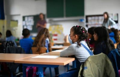 A girl wears a face mask as students sit in a classroom in Germany. (Ina Fassbender/AFP via Getty Images)