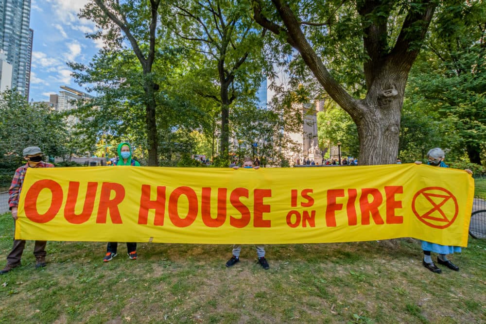 Climate activists holding a banner. A coalition of climate, Indigenous and racial justice groups gathered at Columbus Circle to kick off Climate Week with the Climate Justice Through Racial Justice march, September 21, 2020. (Erik McGregor/LightRocket via Getty Images)