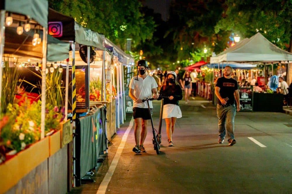 Two people with scooters wear masks walk down 46th Street which has been temporarily converted to "Restaurant Row" for outdoor dining during the fourth phase of the coronavirus pandemic reopening on September 06, 2020 in New York, New York. (oy Rochlin/Getty Images)