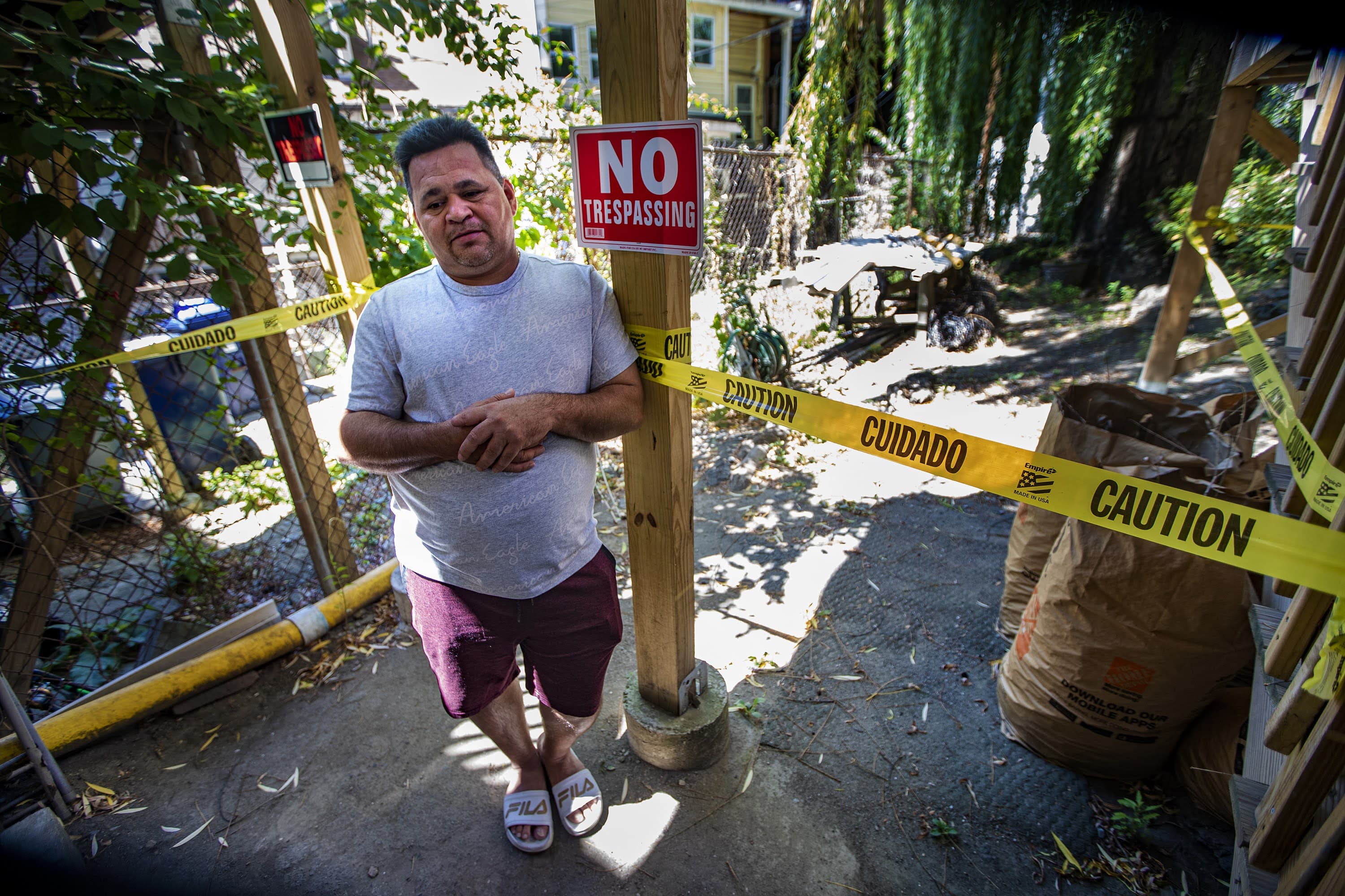 Amid caution tape and no trespassing signs, Marvin Moreno stands outside the apartment where he lived in East Boston. His landlord pressured him to leave, despite the eviction moratorium. (Jesse Costa/WBUR)
