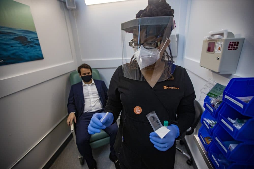 Medical assistant Aneka Gopaulsingh took out the drug swab from the package during the demonstration on Wednesday and performed a nasal swab test on Julian Bernstein, project manager of XpresCheck.  (Jesse Costa/WBUR)