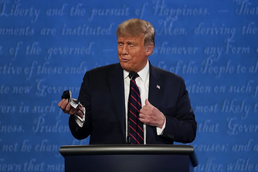 President Donald Trump looks at his facemask during the first presidential debate at Case Western University and Cleveland Clinic, in Cleveland, Ohio. (Julio Cortez/AP Photo)