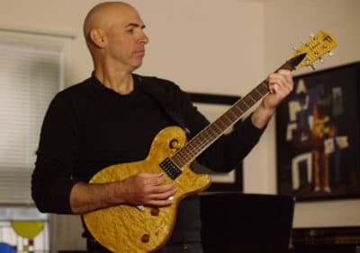 “Eric Shimelonis playing an electric guitar custom built by Jay Pawar.” (courtesy of Rebecca Sheir)
