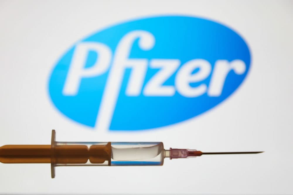 Medical syringe is seen with Pfizer company logo. (Photo illustration by Jakub Porzycki/NurPhoto via Getty Images)