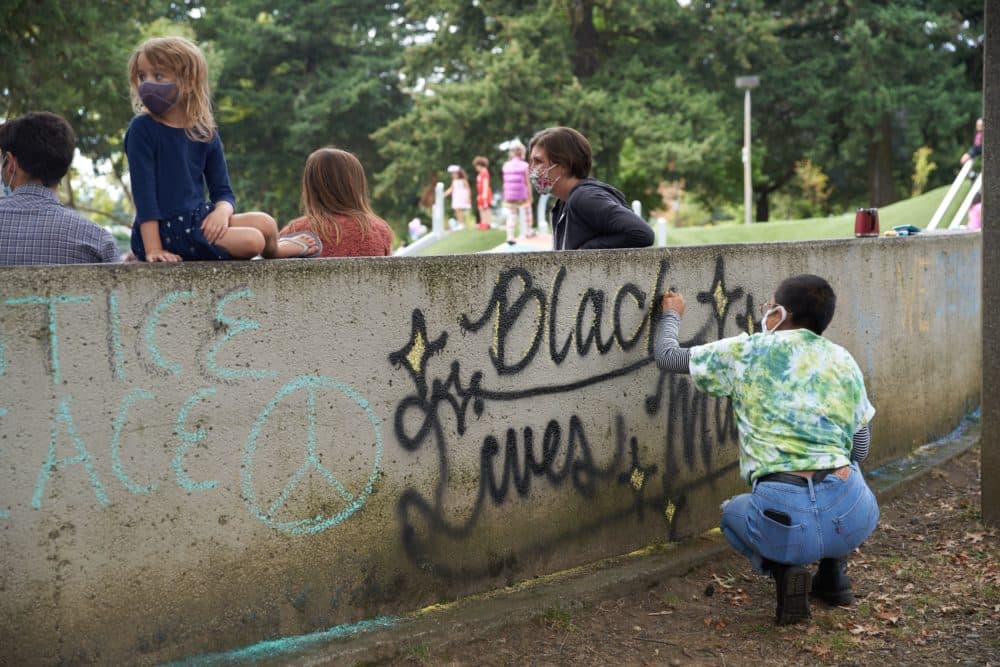 Julia Mapilisan spray paints "Black Lives Matter" on a wall as people gather at Lents Park in Portland, Oregon, on September 5, 2020, to mark the 100th day of protests denouncing police brutality and racism. (Allison Dinner/AFP via Getty Images)