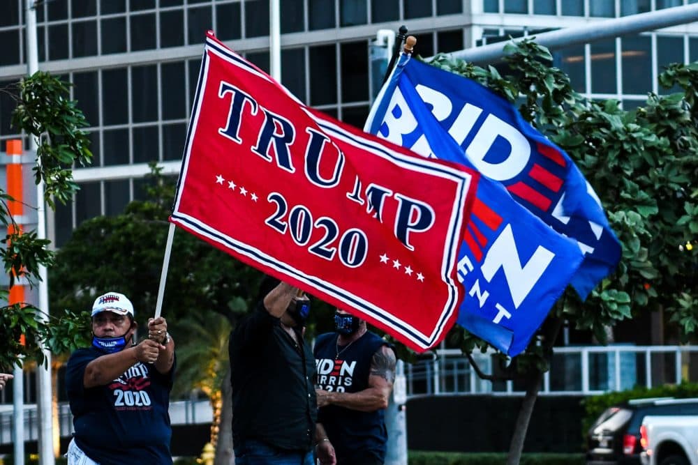 Supporters of US President Donald Trump and Democratic presidential nominee and former Vice President Joe Biden wave flags prior to Biden's arrival for an NBC townhall outside of the Perez Art Museum in Miami, Florida on October 5, 2020. (Chandan Khanna, AFP via Getty Images)